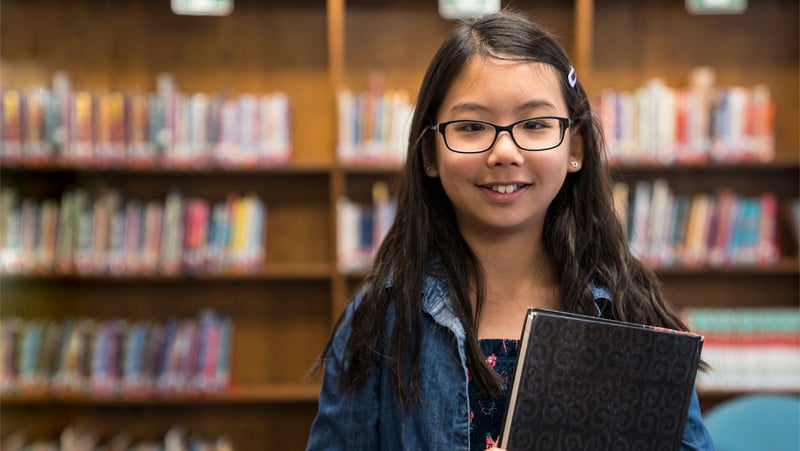 asian teenage girl with eyeglasses in school libra MZLETP